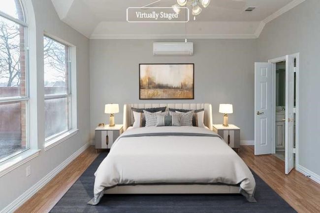 Bedroom with lofted ceiling, an AC wall unit, baseboards, and wood finished floors | Image 10