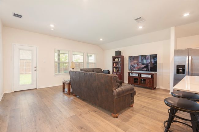 Living room with light wood finished floors, vaulted ceiling, and recessed lighting | Image 20