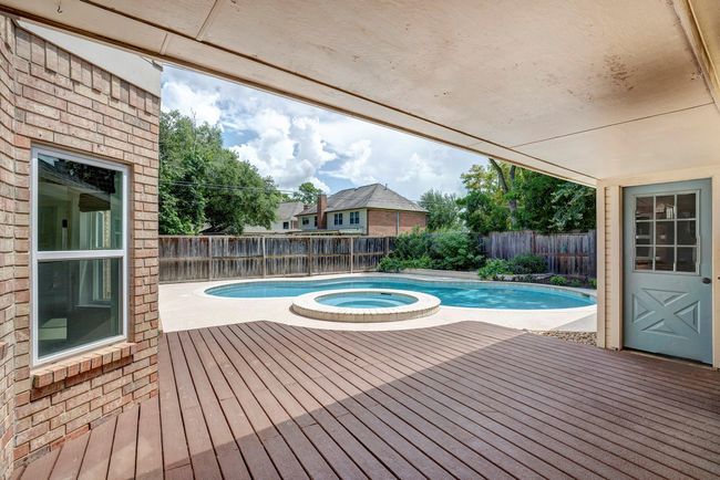 A covered deck connects to the two car garage. | Image 16