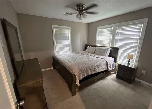 Carpeted bedroom with visible vents, ceiling fan, and baseboards | Image 6
