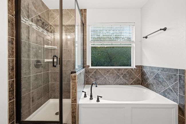 Bathroom featuring a bath and a shower stall | Image 8