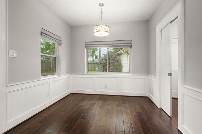 Breakfast room extends to the back of the home, showcasing beautiful windows with custom window treatments and a charming chandelier that adds warmth and character to the space. | Image 12
