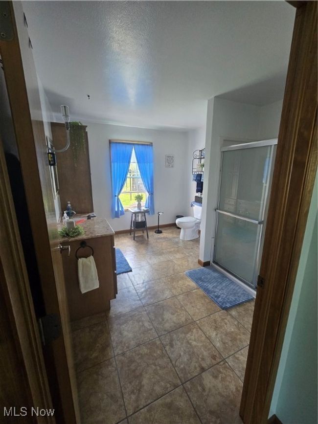Full bathroom featuring toilet, baseboards, and a stall shower | Image 35