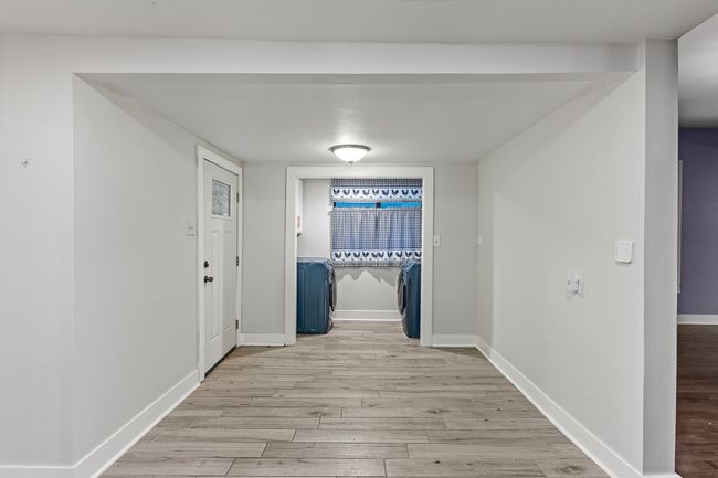 Corridor featuring washing machine and clothes dryer, light wood-style flooring, and baseboards | Image 22