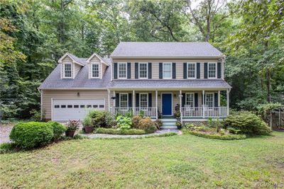 Colonial-style house featuring covered porch and a front lawn | Image 1