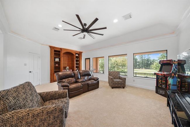 With pre-wiring for ceiling speakers, a floor-to-ceiling custom built-in is perfect as an entertainment center while fixed glass windows and a glass door overlook the golf course from the second floor of this fabulous home! | Image 27