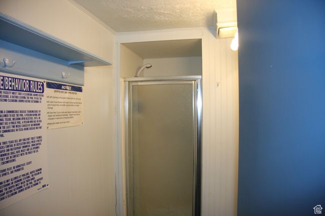Full bathroom featuring a textured ceiling and a shower stall | Image 7