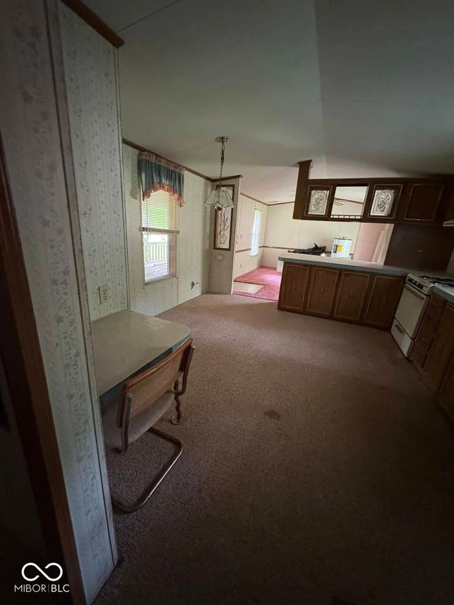 unfurnished living room featuring carpet and wallpapered walls | Image 10