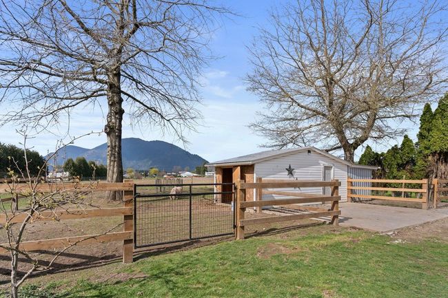 View of yard with an outbuilding, a mountain view, fence, and a gate | Image 20
