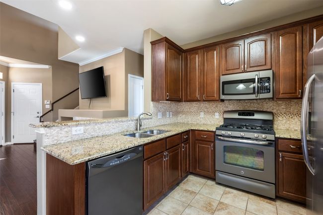 Kitchen with tasteful backsplash, appliances with stainless steel finishes, sink, and pantry. | Image 4
