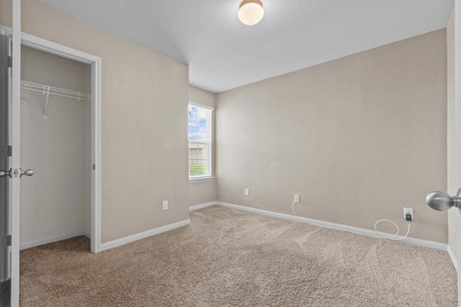 Unfurnished bedroom with baseboards, carpet flooring, and a closet | Image 16