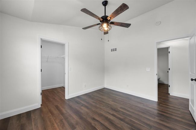 Unfurnished bedroom featuring visible vents, baseboards, dark wood-type flooring, and a spacious closet | Image 13