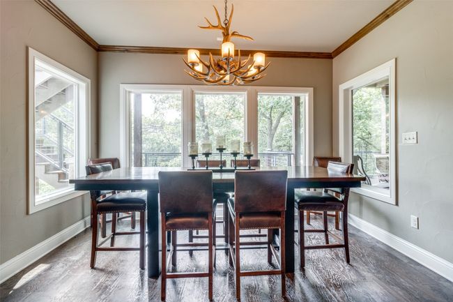 Dining area featuring a notable chandelier, a healthy amount of sunlight, and dark wood-type flooring | Image 9