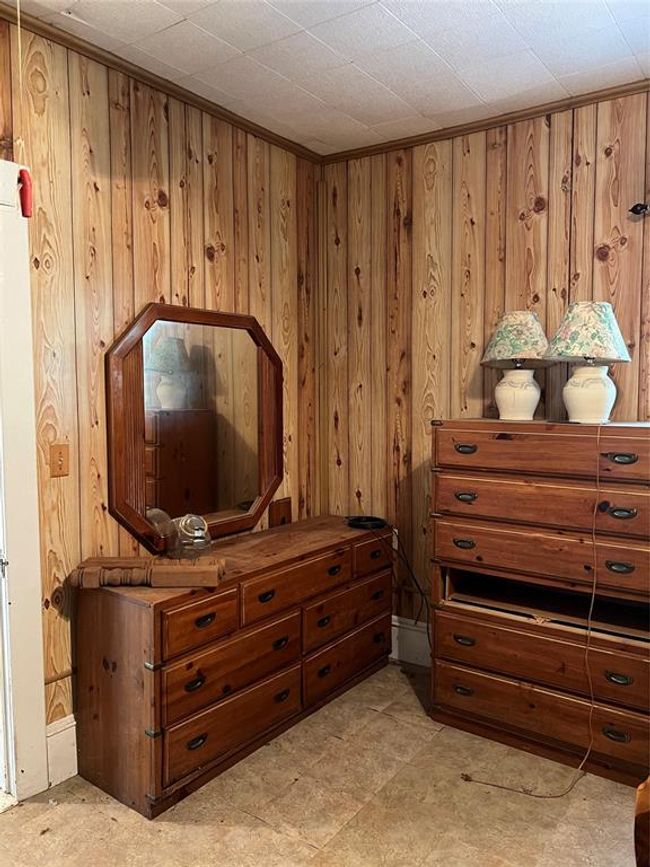 Bedroom with wood walls and light tile flooring | Image 31