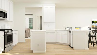 Kitchen with white cabinets, appliances with stainless steel finishes, a kitchen island, and light hardwood / wood-style floors | Image 3