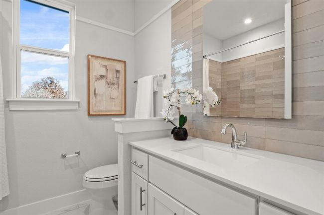 Full bath featuring marble finish floor, toilet, vanity, baseboards, and decorative backsplash | Image 25