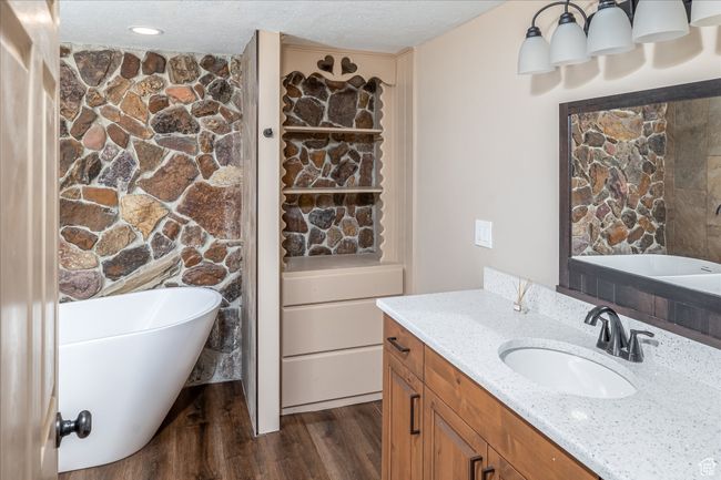 Full bathroom with a soaking tub, vanity, wood finished floors, and a textured ceiling | Image 29