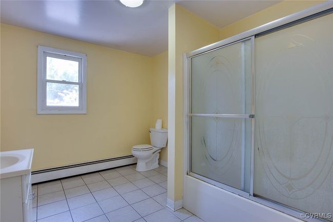 2nd Full bathroom featuring tile patterned flooring, toilet, shower / bath combination with glass door, a baseboard radiator, and vanity | Image 17