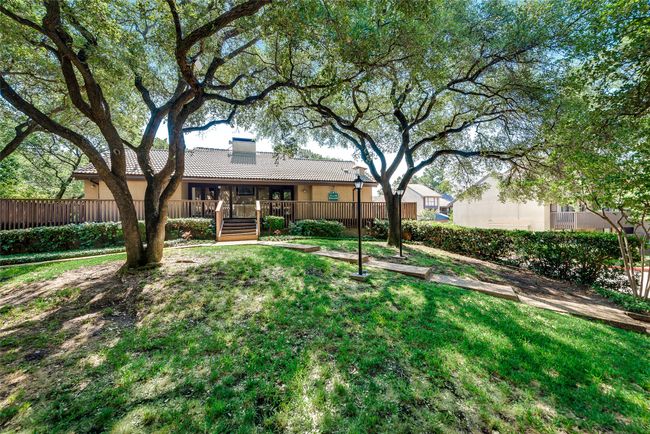 Rear view of house with a yard, a tile roof, stucco siding, and a chimney | Image 26