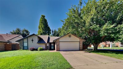 Ranch-style home featuring a garage and a front lawn | Image 1