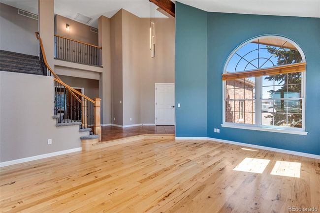 Entryway featuring high vaulted ceiling, visible vents, stairway, wood finished floors, and baseboards | Image 5