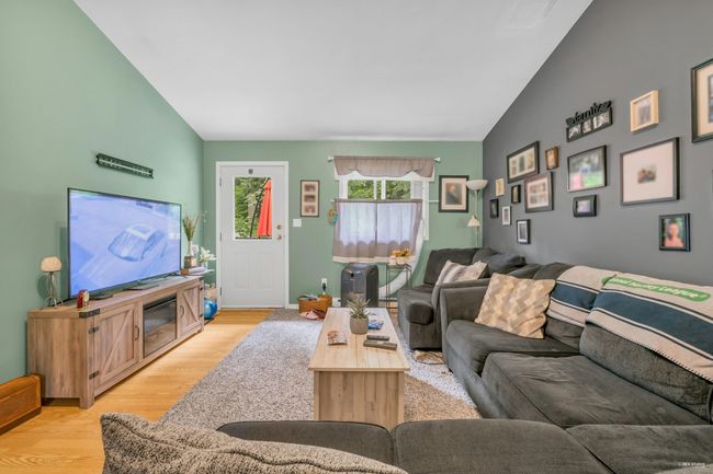 Living room with lofted ceiling, light wood finished floors, and baseboards | Image 24
