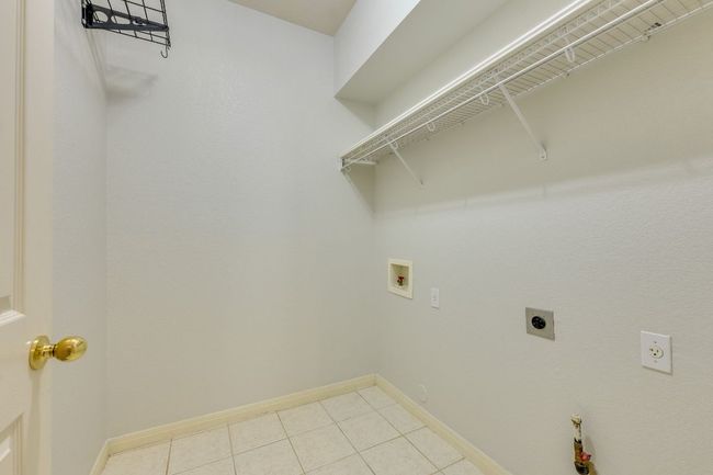 Laundry area with hookup for an electric dryer, hookup for a washing machine, and tile patterned floors | Image 29