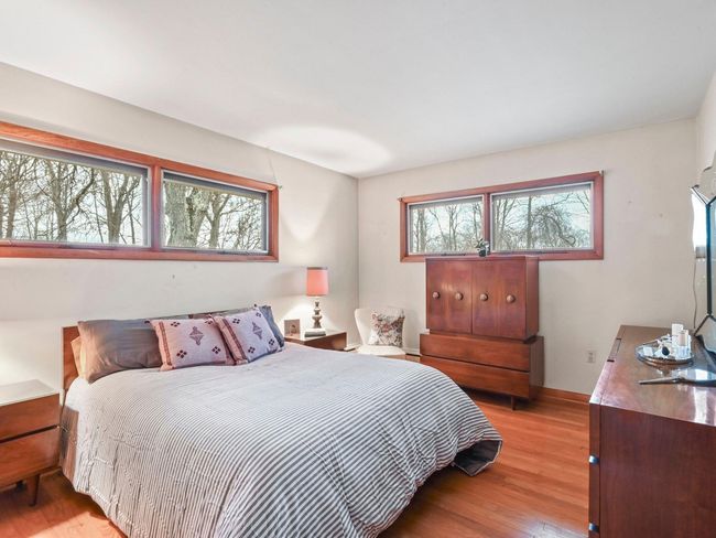 Bedroom with light wood-type flooring | Image 21