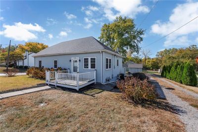 View of front of home featuring central AC, a wooden deck, and a front lawn | Image 3