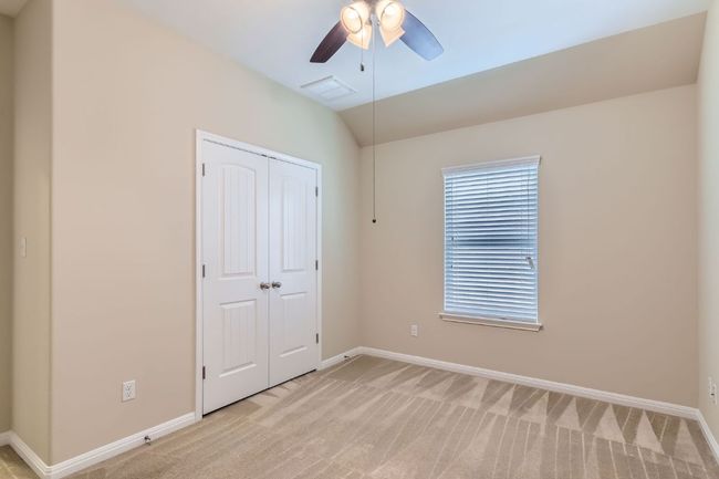 Bedroom 3 with light carpet, a closet, lofted ceiling, and ceiling fan | Image 24
