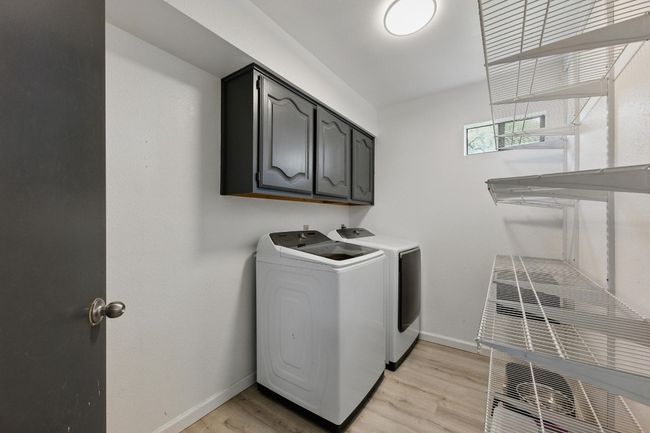 The laundry room is equipped with recently installed shelves, offering extra storage space for added convenience and organization. | Image 26