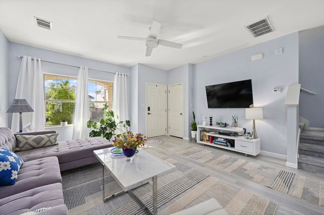 Living area with stairway, baseboards, visible vents, and light wood-type flooring | Image 11