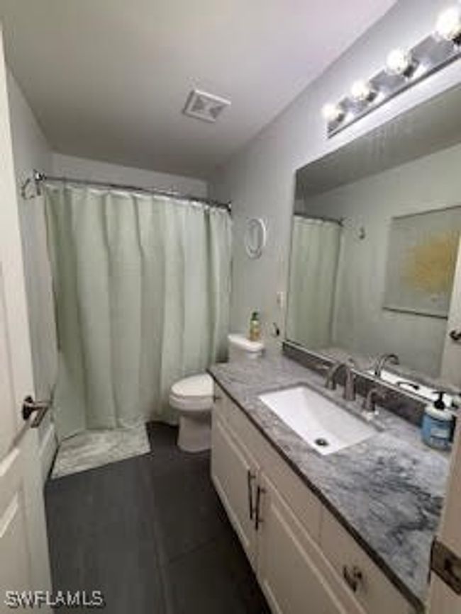 Bathroom with visible vents, toilet, vanity, and a shower with shower curtain | Image 21