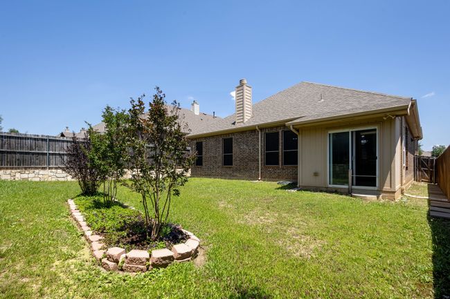 Back of property with a chimney, brick siding, and a shingled roof | Image 31