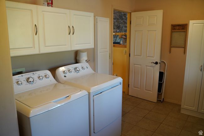 Washroom with independent washer and dryer, cabinet space, and tile patterned flooring | Image 17