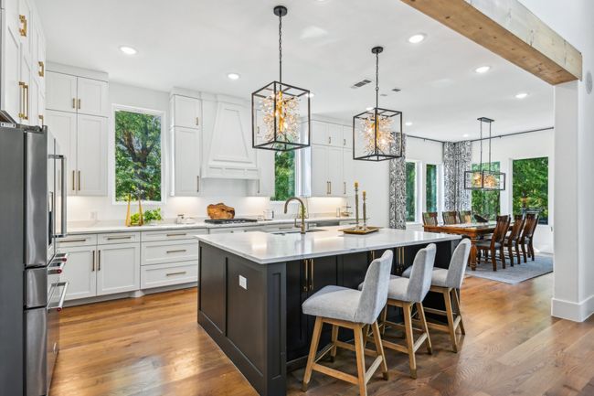 Kitchen featuring freestanding refrigerator, recessed lighting, light countertops, white cabinets, and a chandelier | Image 11