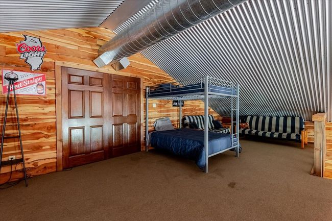 Bedroom with wood walls and carpet floors | Image 15