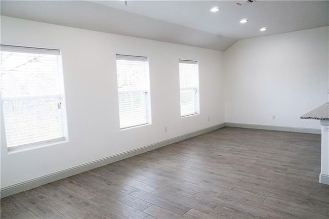 Unfurnished room with wood finished floors, vaulted ceiling, baseboards, and recessed lighting | Image 6