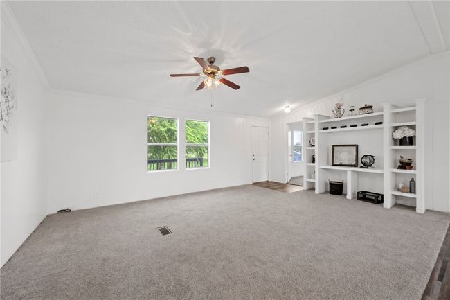 Unfurnished living room featuring ornamental molding, ceiling fan, and carpet | Image 7