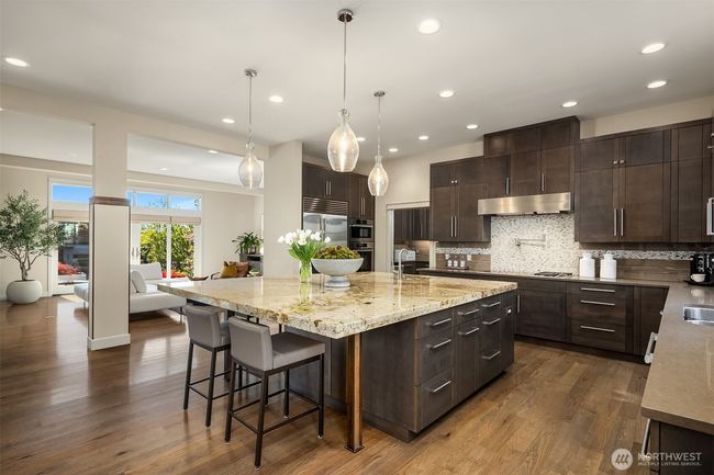 Everyone's gathering around the island and you can see why! Great amenities like the catering kitchen and pantry make entertaining feel fun. Such a great floor plan you have to come see! | Image 11
