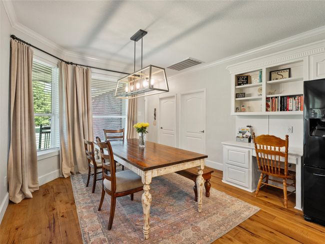 Dining space with crown molding, a chandelier, light wood-style floors, and a desk | Image 8