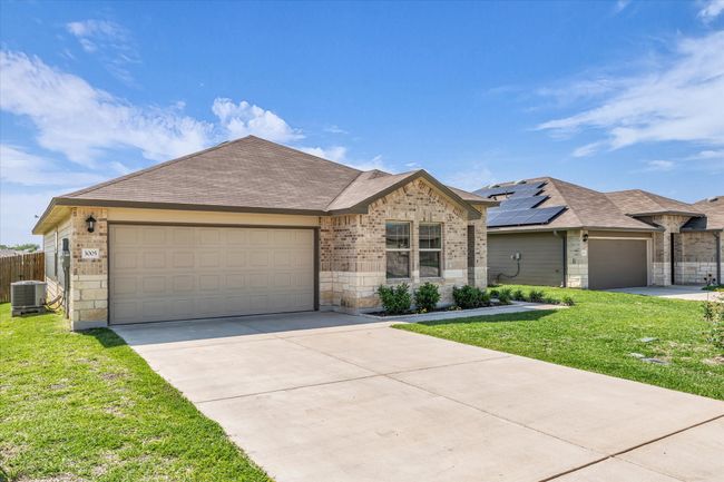 Ranch-style house with central AC unit, brick siding, concrete driveway, and a garage | Image 27