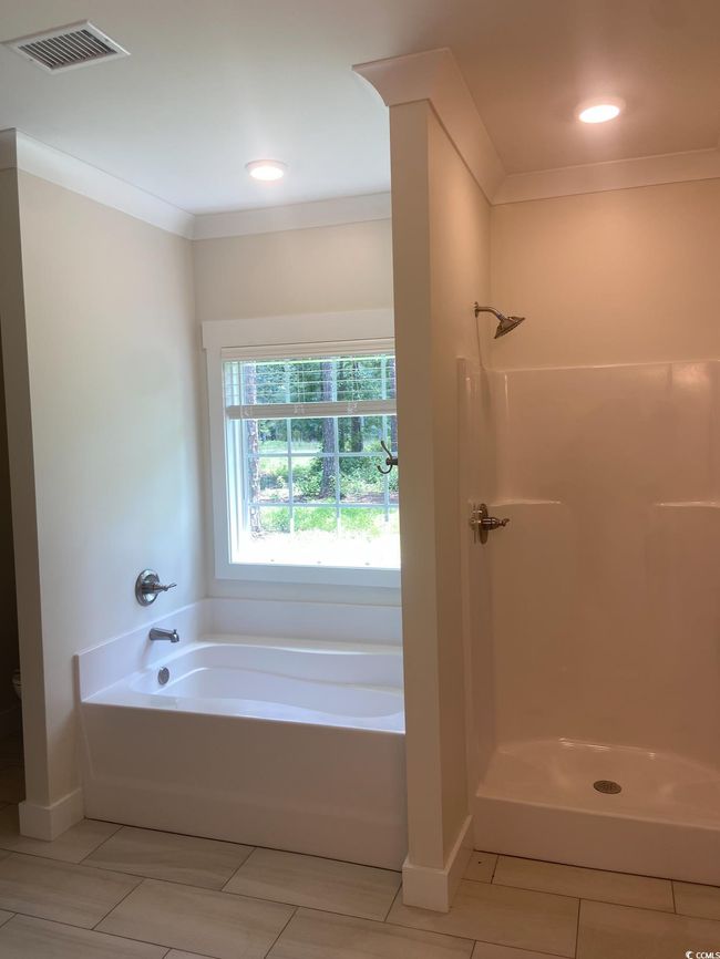Bathroom featuring a bath, a shower, ornamental molding, and tile patterned flooring | Image 29