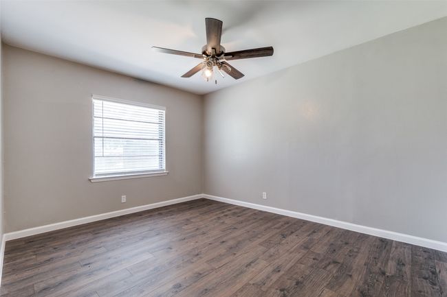 Spare room featuring a ceiling fan and dark wood-style floors | Image 22