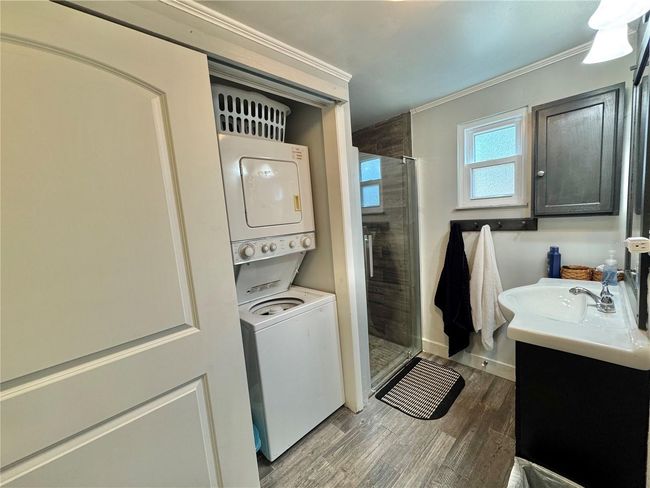 Primary full bathroom with stand up shower and barn door to cover laundry closet with stackable washer/dryer | Image 17