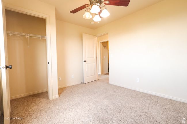 Unfurnished bedroom with carpet floors, a closet, and ceiling fan | Image 13