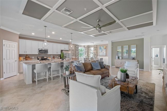 Living room with visible vents, light tile patterned floors, ornamental molding, ceiling fan, and coffered ceiling | Image 11