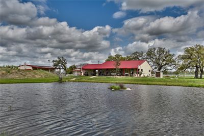 View of fishing pond and back of main house, south barndo to the left. Zipline off to the right. | Image 1