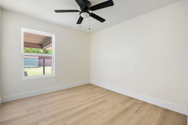 Spare room featuring light wood-style flooring and a ceiling fan | Image 12
