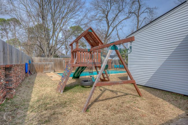 View of jungle gym featuring a fenced backyard and a lawn | Image 7
